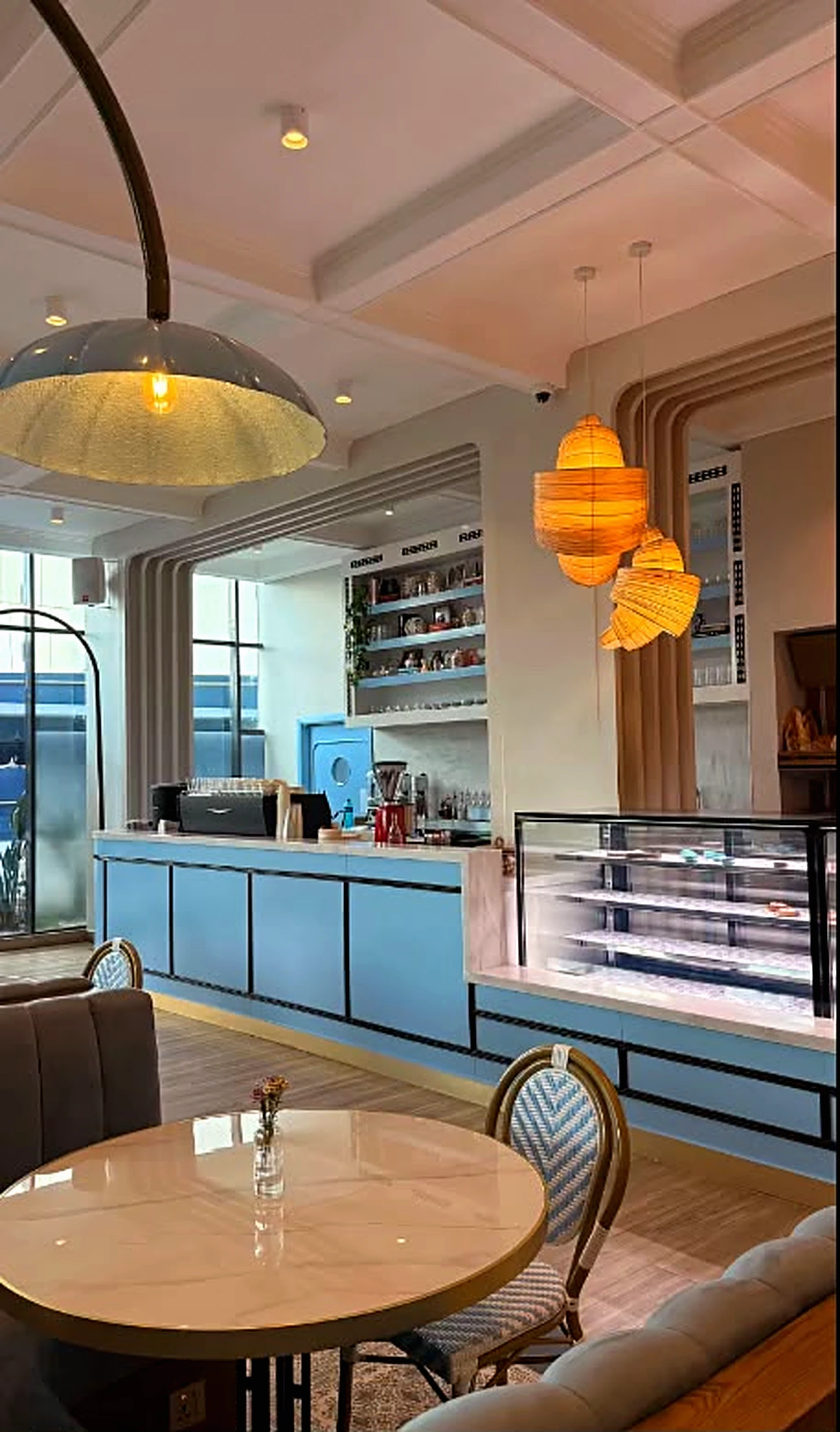 Maison's signature wall of warm lamps and the blue counter front